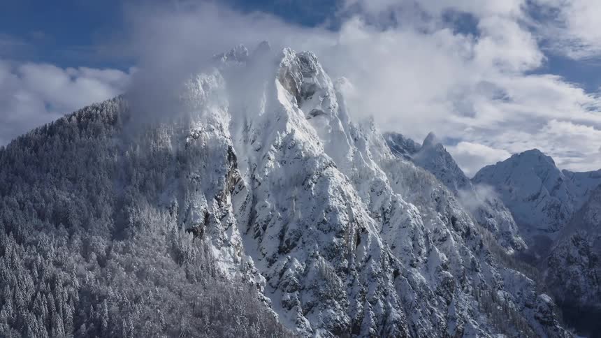 The clouds touch the top of the tall mountain