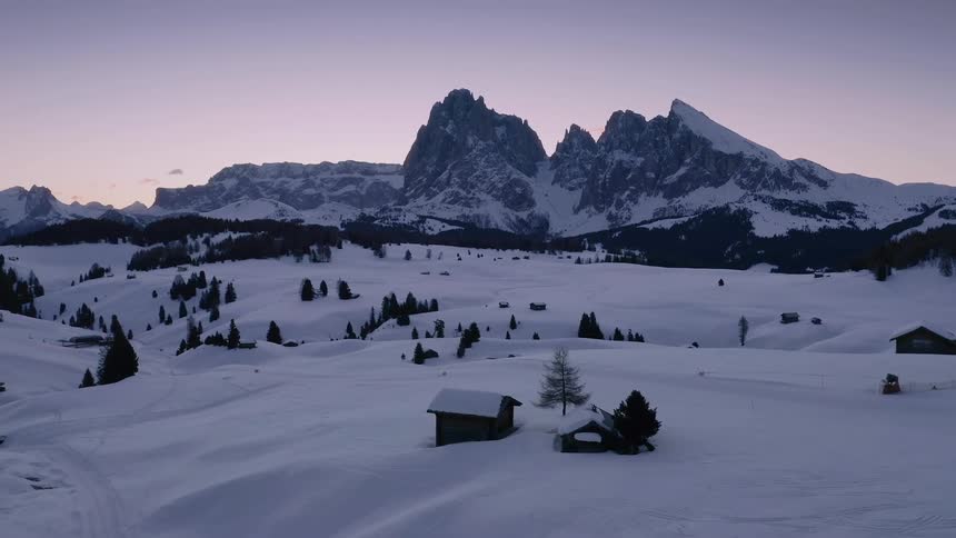 Two small buildings buried in snow in a rural area