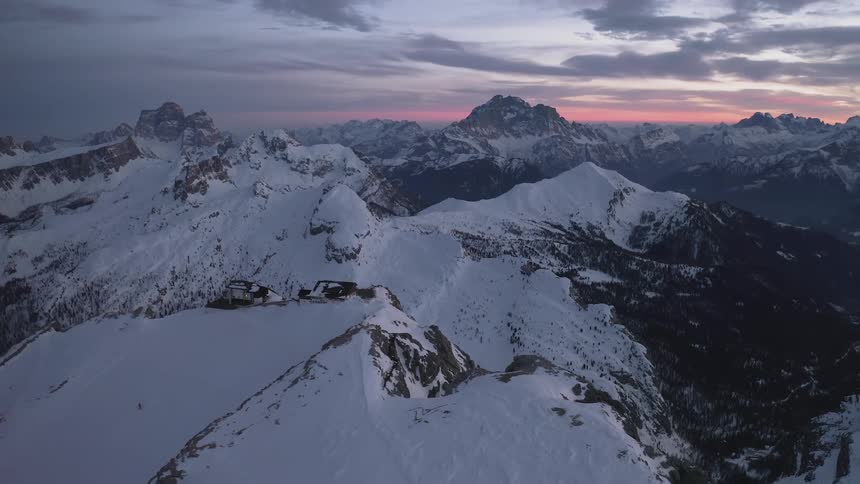 Aerial view of high snow capped mountains at sunset