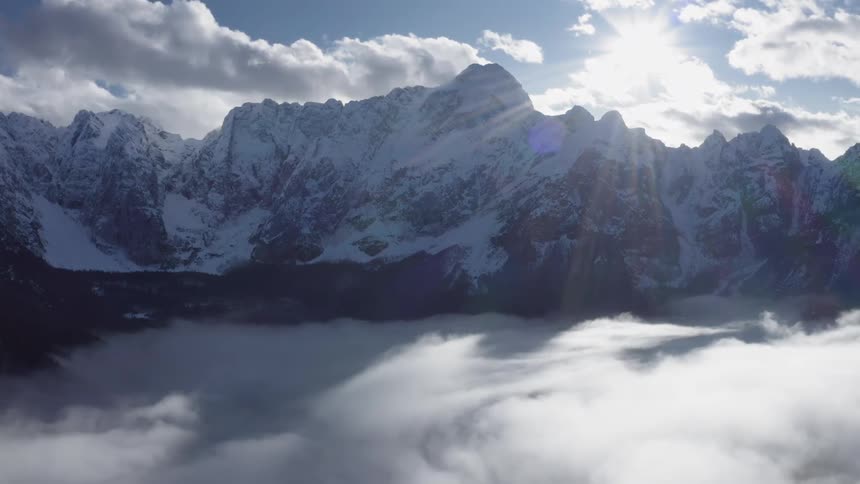 Snow covered land and mountains under a sunny blue sky