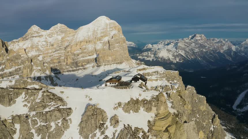 A building located on the snowy cliff of a mountain at high altitude