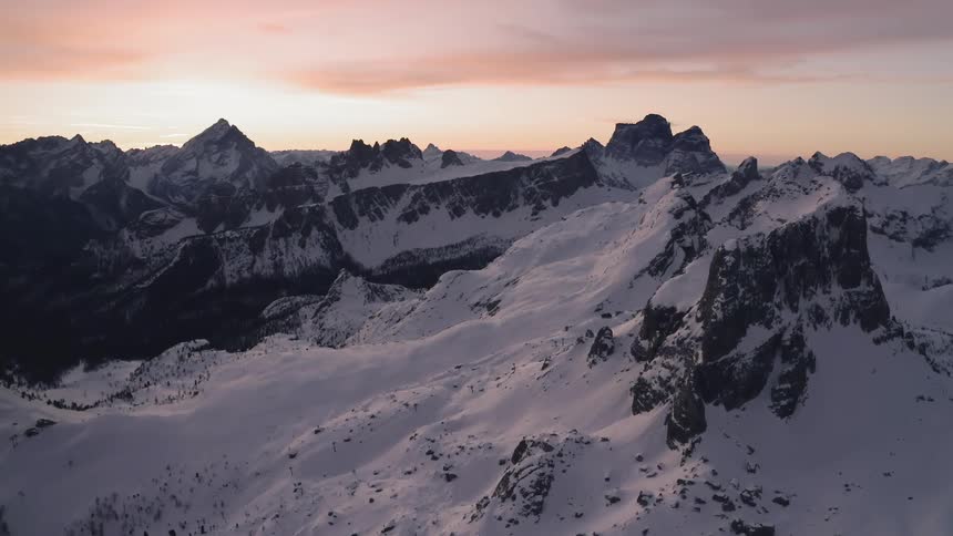 Aerial view of snow covered mountain range at sunset