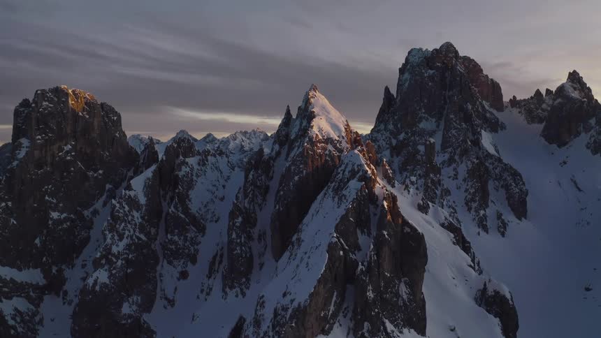 Snow settles in the cracks and valleys of a mountain range