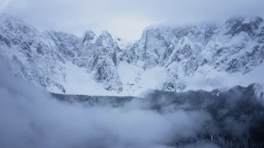 Fog starts to cover a snow covered canyon