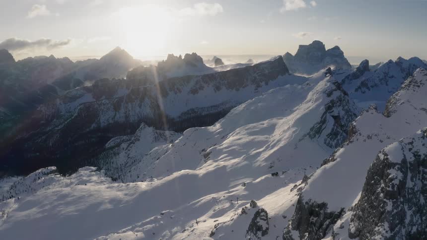 A snow covered mountain range under a partly cloudy sky