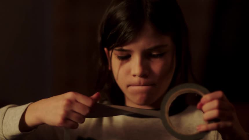 A young boy roughly pulls on a roll of duct tape