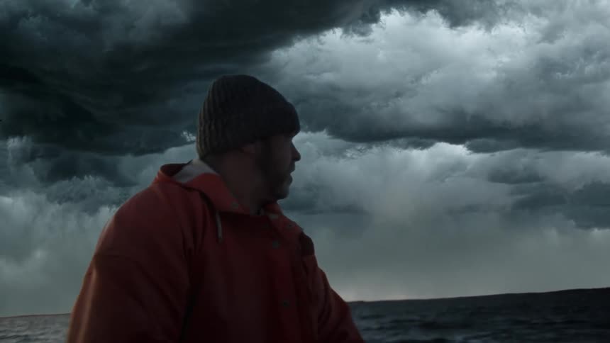 A man is on the ocean when its storming outside