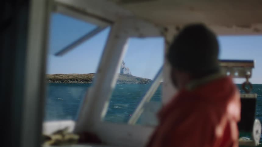 A boat captain steers the vessel in rocky water