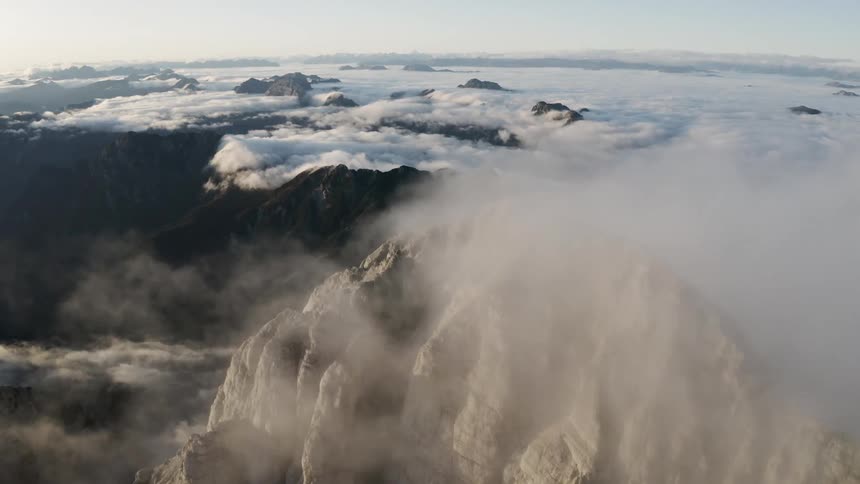 Heavy fog starts to set over snow covered mountains