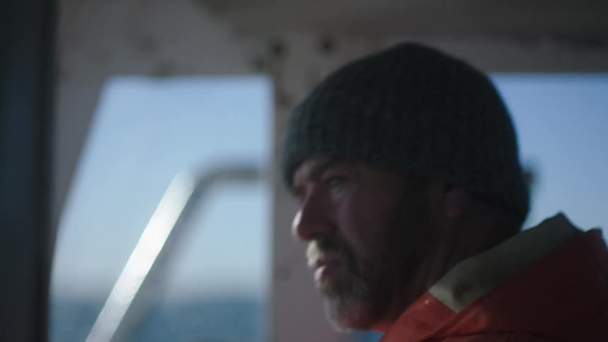 Captain in the cockpit of a fishing boat in the ocean