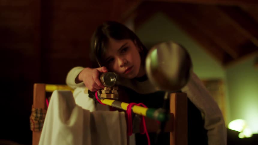 A young girl turns on a light and looks in a mirror