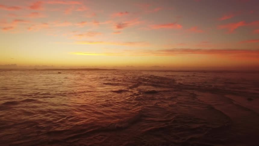 Waves flow and crash into shore at dawn