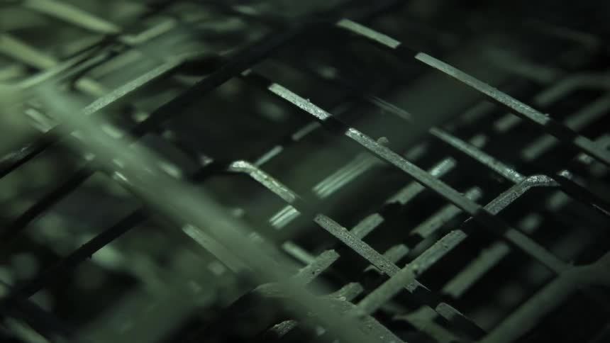 Shadows passing over close up of metal grate texture