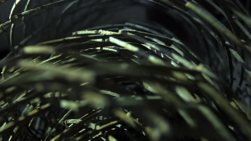 Close up of roll of wire fence on a dimly lit room