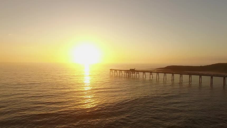 Waves flowing towards shore during sunset