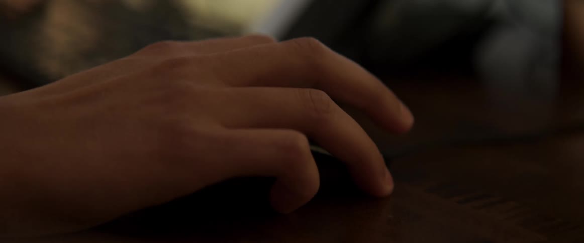 A persons hand typing on a keyboard and moving a mouse