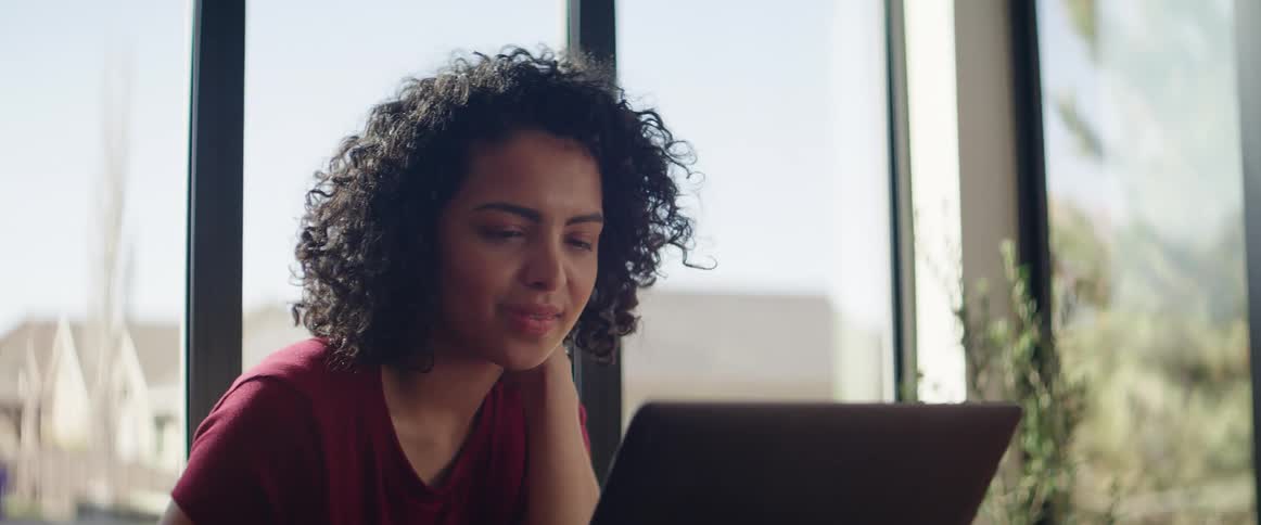 A woman is talking on a laptop