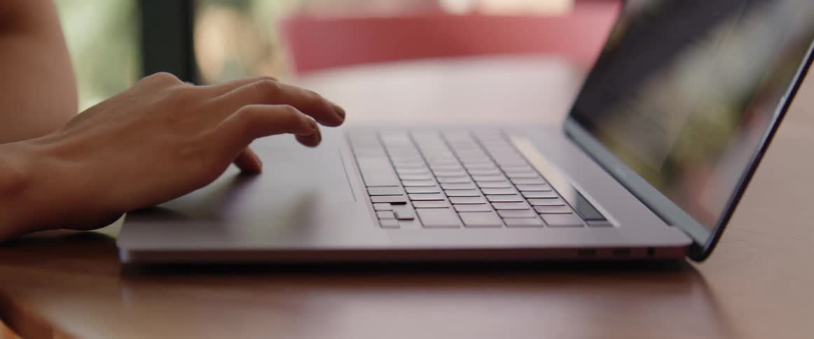 A woman is typing on a laptop