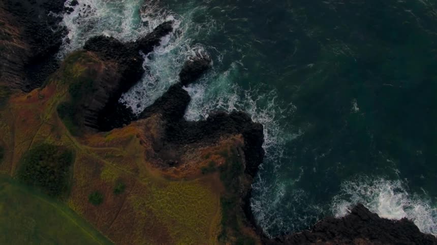 Aerial view of a cliff leading to a body of water