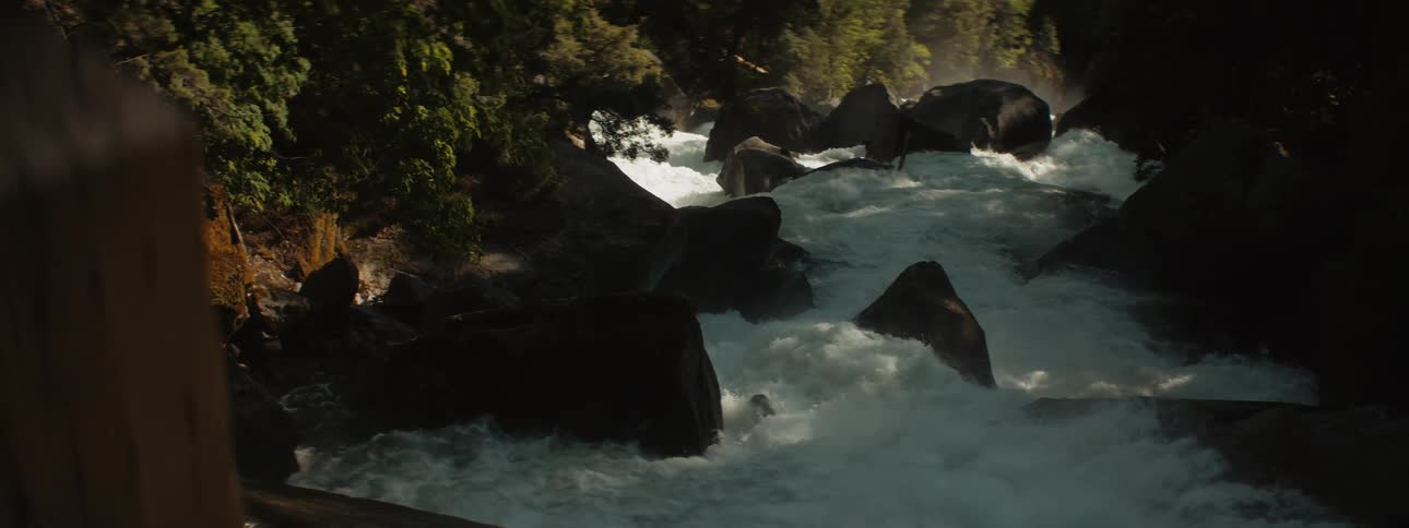 A wooden post hides a churning river rapids