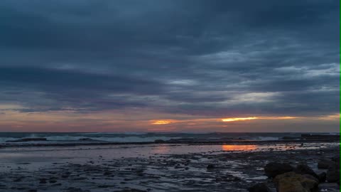 Rising sun through storm clouds on the coast