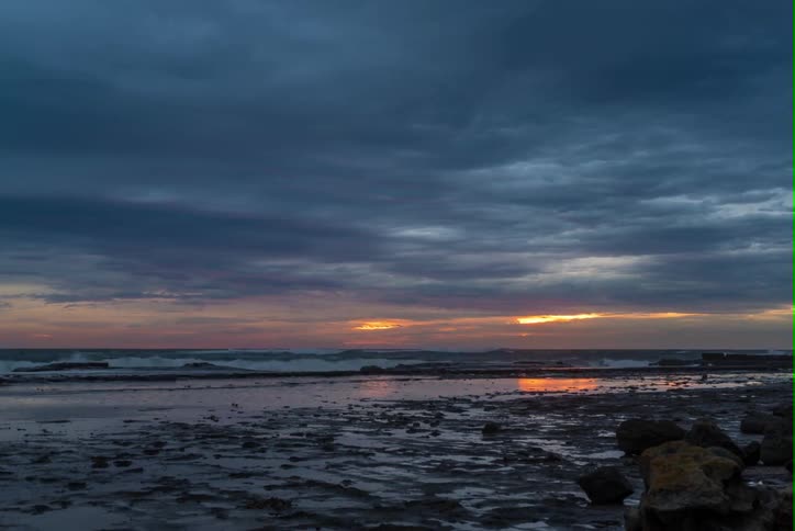 Rising sun through storm clouds on the coast