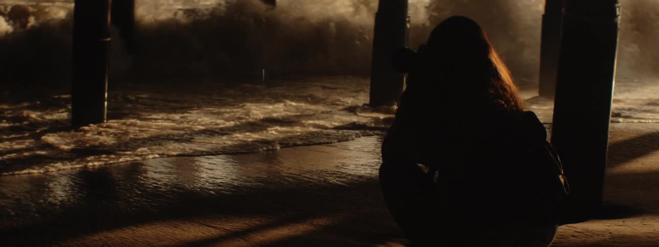 A woman on the beach with a camera taking pictures