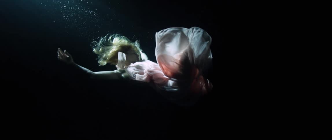 Model in gown floats and twists gracefully underwater