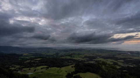 Clouds pass over a vast green plain