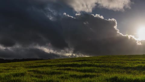 Timelapse of clouds gathering and blowing over a field