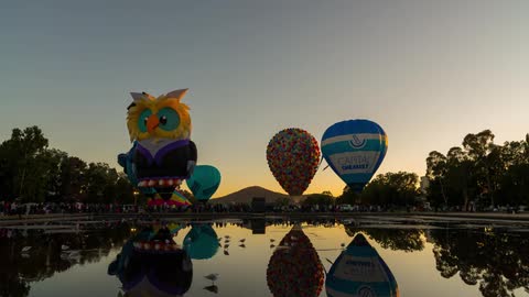 Time lapse of a festival with hot air balloons being filled at sunrise