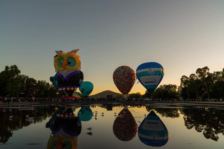 Time lapse of a festival with hot air balloons being filled at sunrise