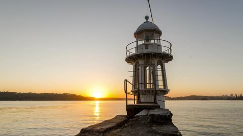 Timelapse of harbour lighthouse with rising sun