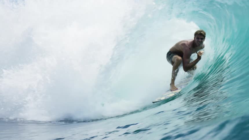 Surfer surfing through a wave barrel in the ocean