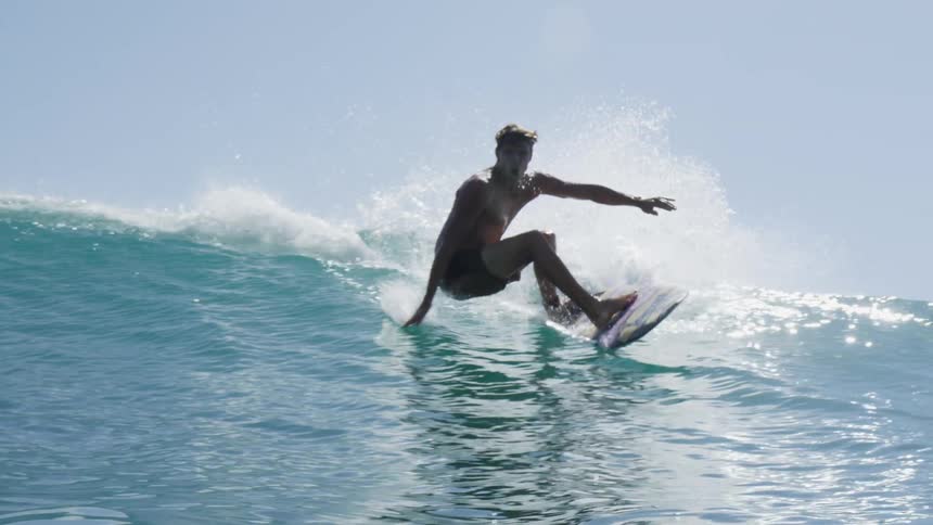 A man in a surfboard surfing in the ocean with the sky in the background