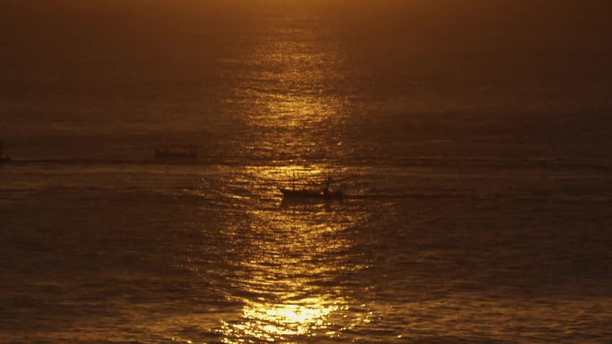 A boat in the water as the sun sets
