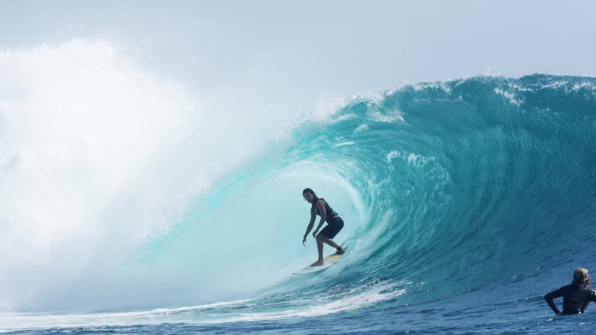 Surfer rides a wave on a surfboard in the ocean