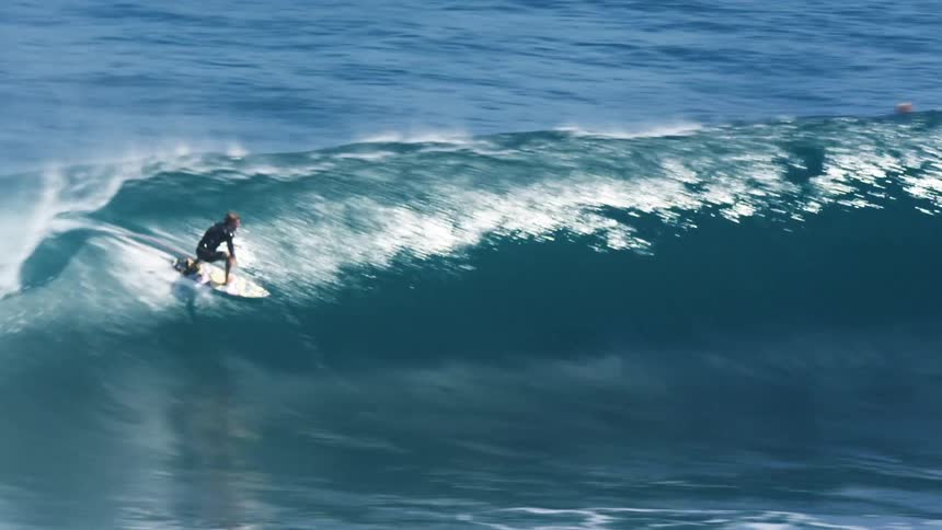 Surfer rides an ocean wave with a surfboard