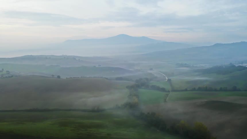 Farmland and fields fill a mountain valley in a rural area