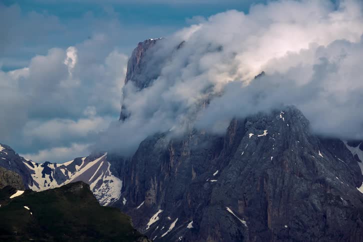 Dense floating clouds obscure the peaks of a mountain range