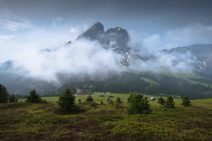 A large house and property sit alone below a mountain range