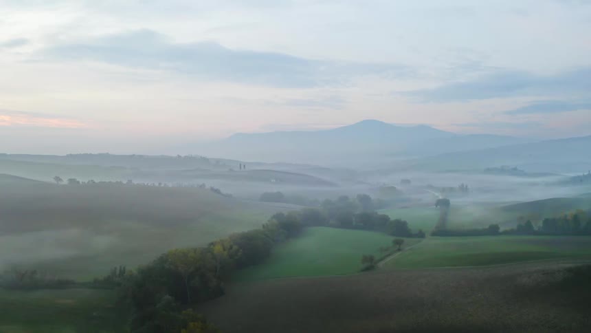 Aerial view of mist covered hills at sunset