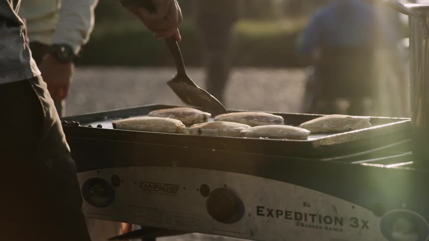 A man cooks pancakes outside