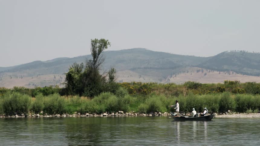 A group of men in small boat on a river