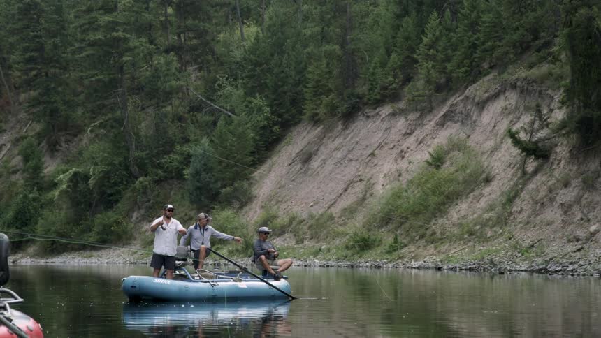 Three men fish from a boat in a lake