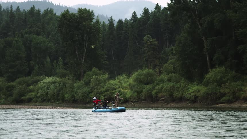 Fishermen fishing on a lake in the mountains on an inflatable boat