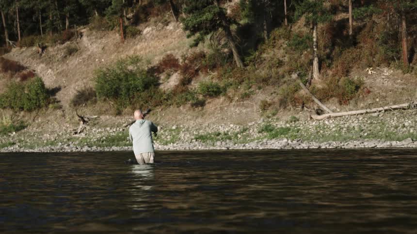 A man standing in the water fishing