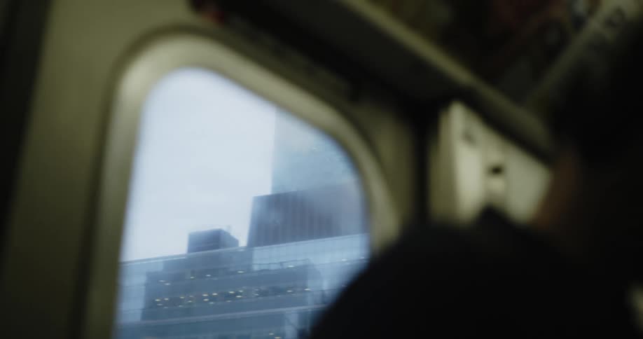 City buildings seen through the window of a train car