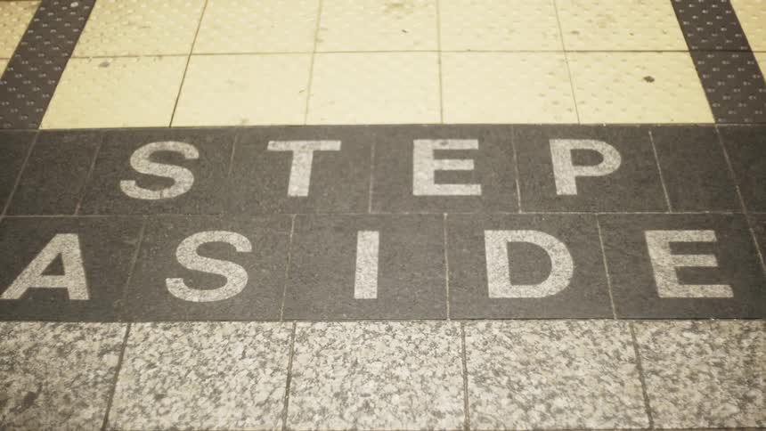 A person walks over a notice on the floor in a city