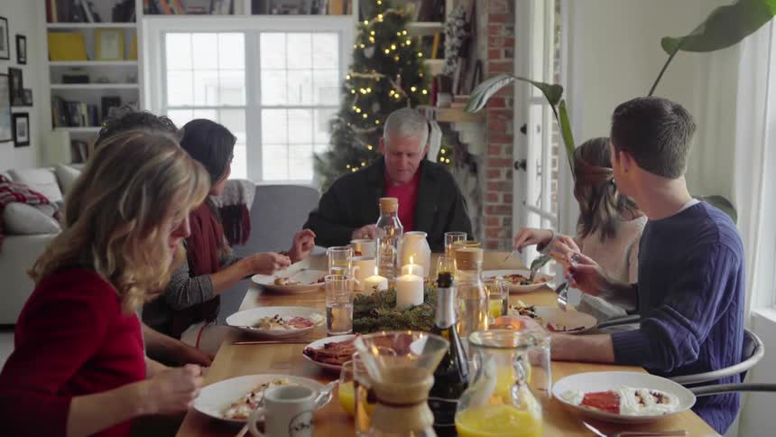 A white family enjoys a holiday meal at a dining room table